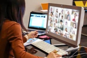 Online conference meeting with woman attending on her desktop computer.