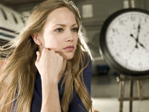 pensive woman with clock in background