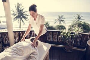 woman performing massage with an ocean background