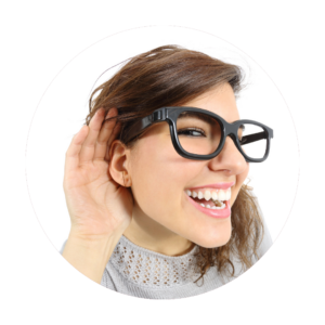 Woman with glasses smiling widely, hand cupped behind her ear as if listening intently, isolated on a white background.