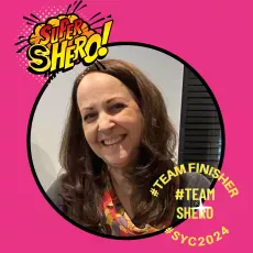 A smiling woman featured within a pink circular frame, with superhero-themed graphics and text overlays such as "super shero!", "#teamfinisher #teamsheno #syc2024.